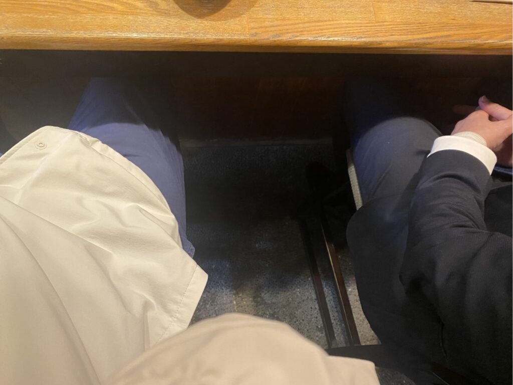 お寿司屋さんのカウンターに座る2人